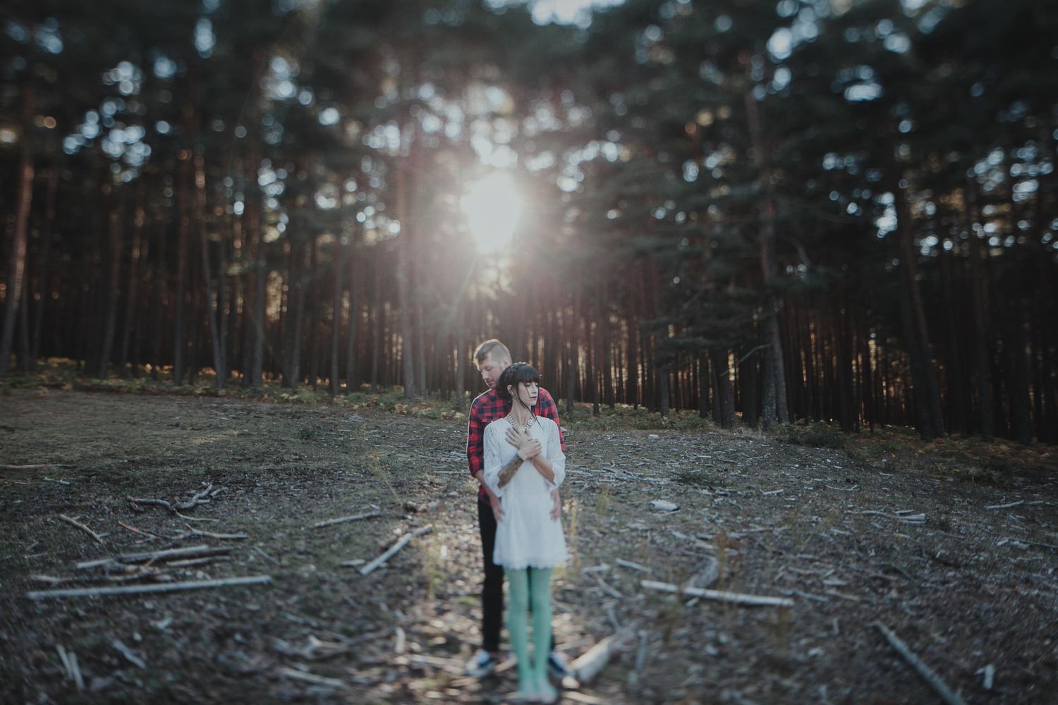 Ethereal forest portrait with sunburst light filtering through pine trees.