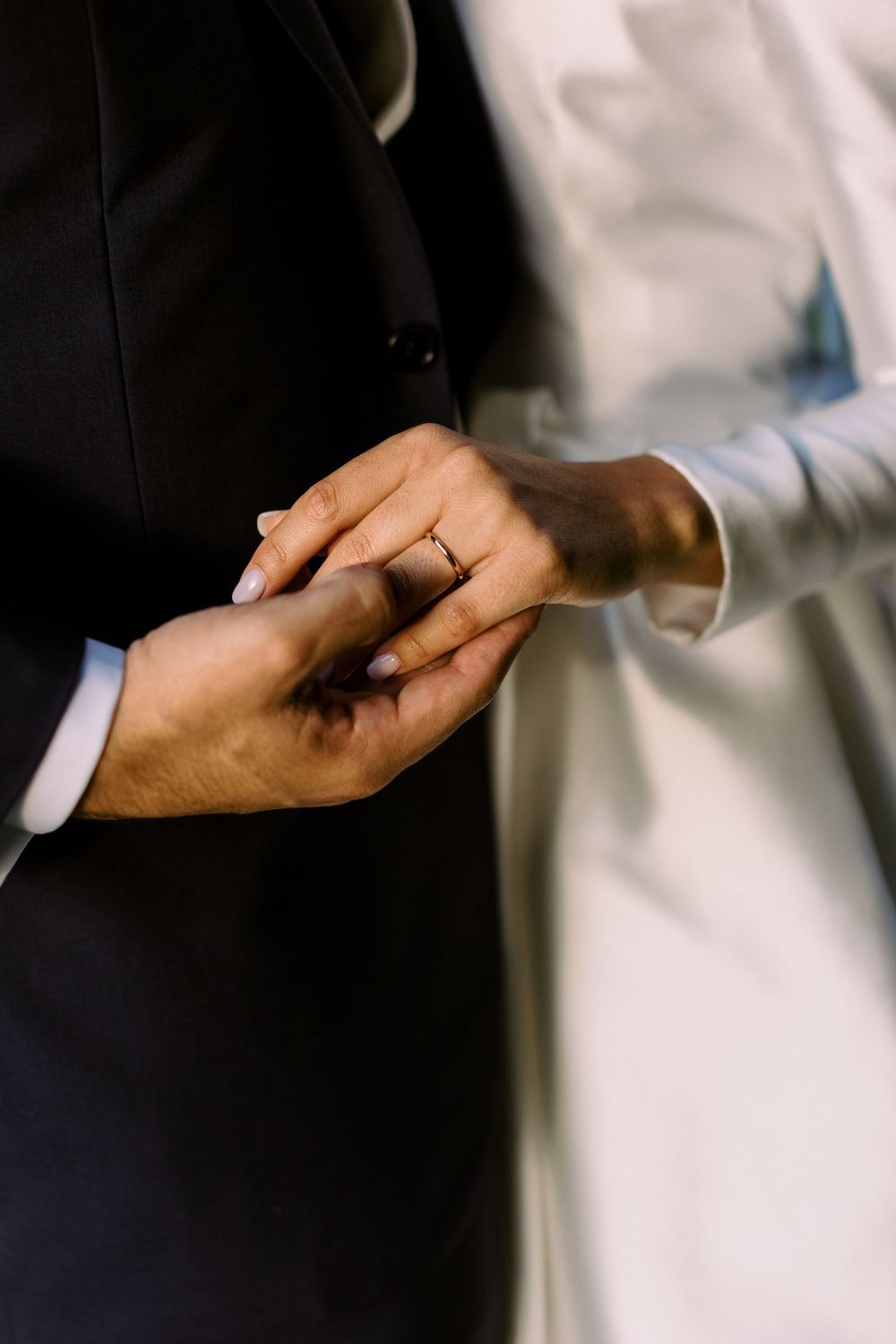 A close-up of hands exchanging wedding rings during a ceremony.