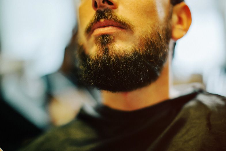 Close-up profile shot of a well-groomed beard against dark background.