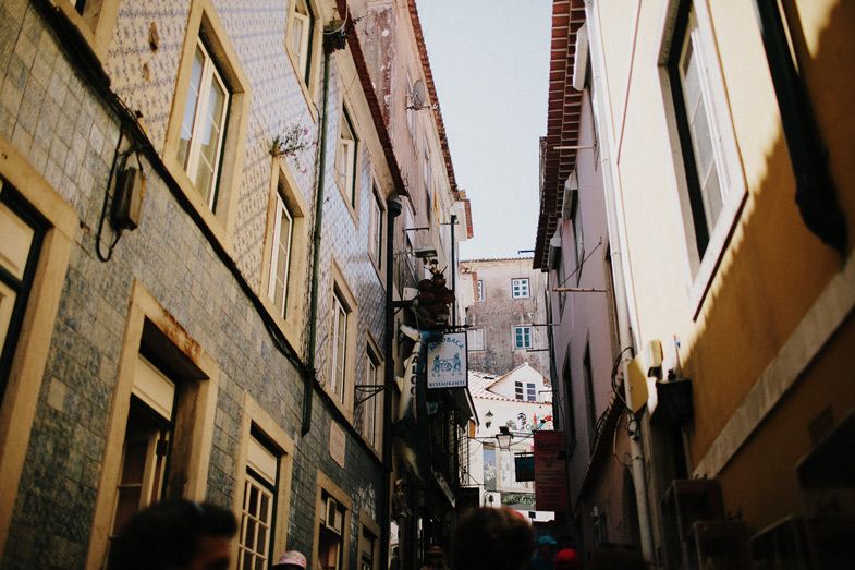 Narrow cobblestone alley between old stone buildings in a historic European neighborhood.