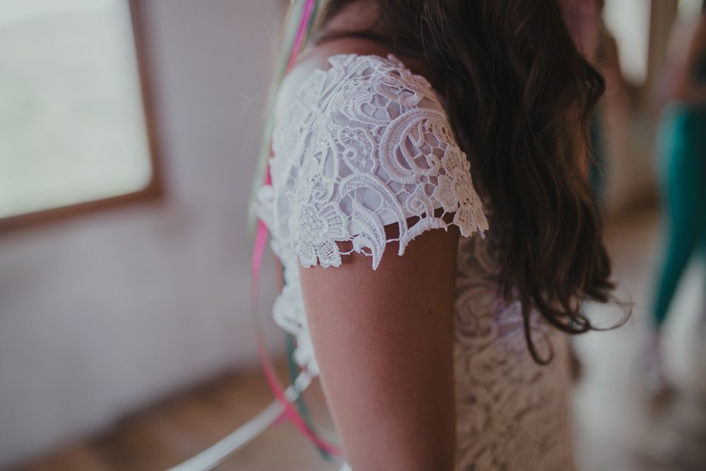 Close-up of delicate white lace sleeve detail on a wedding dress.