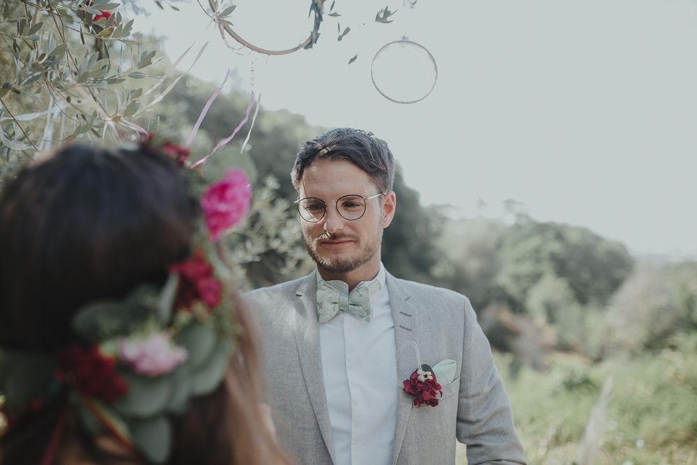 Intimate wedding ceremony in garden setting with bubbles floating through the air.