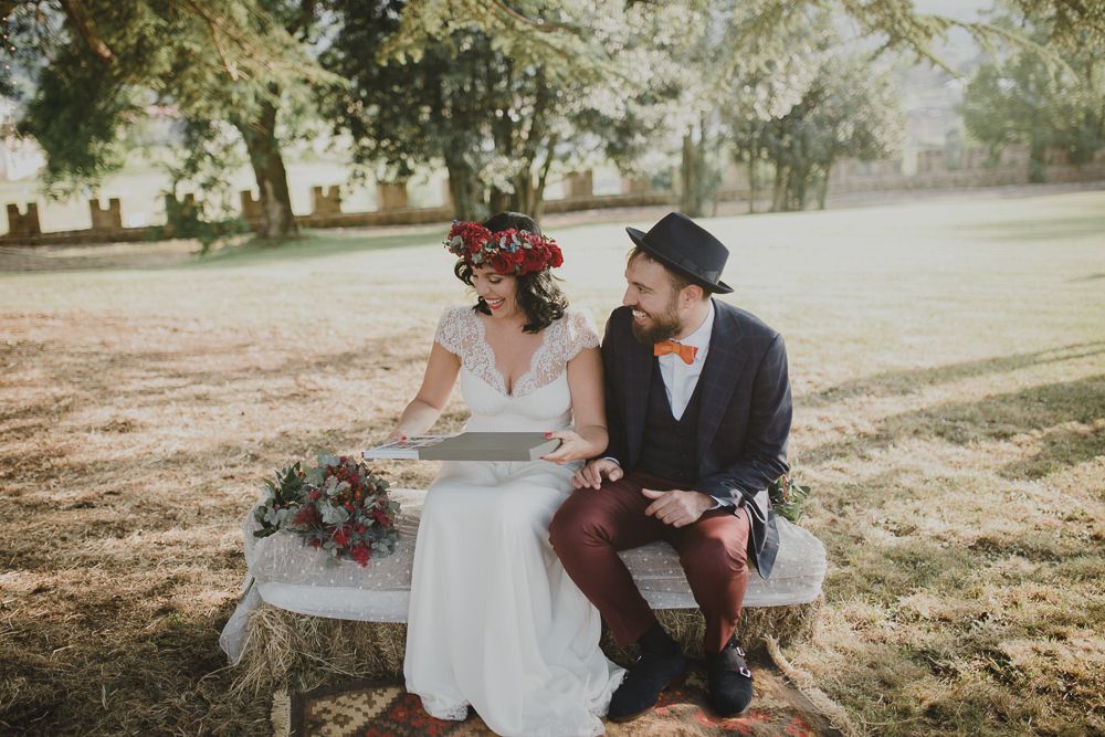 A couple enjoys a quiet moment together on a bench during their outdoor wedding ceremony.