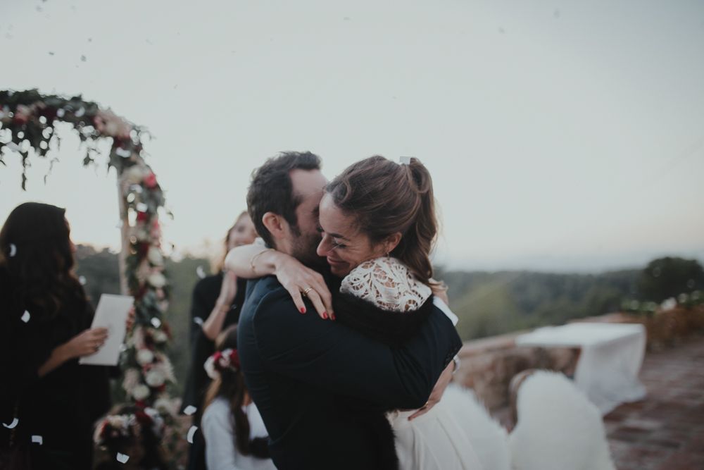 A romantic embrace captured during an outdoor wedding ceremony with scenic views.