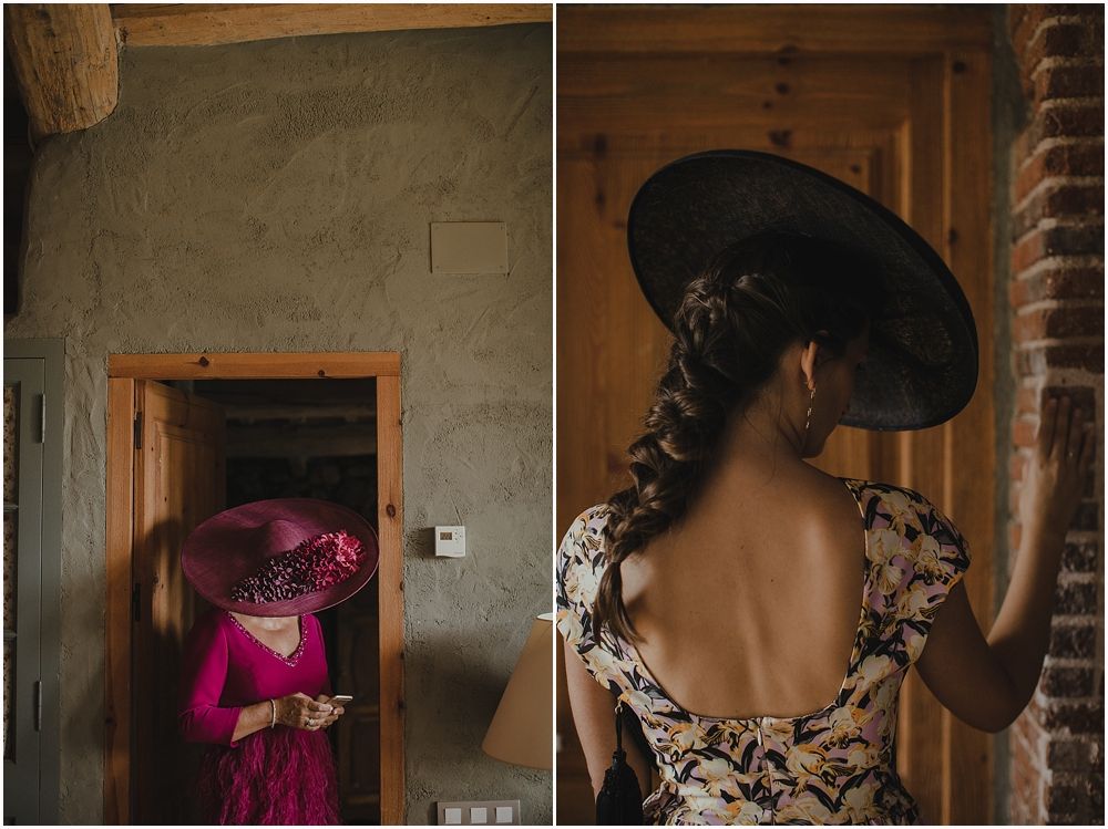 Two guests wearing elegant attire pose in dramatic lighting at a formal event, with one in floral and one in magenta.