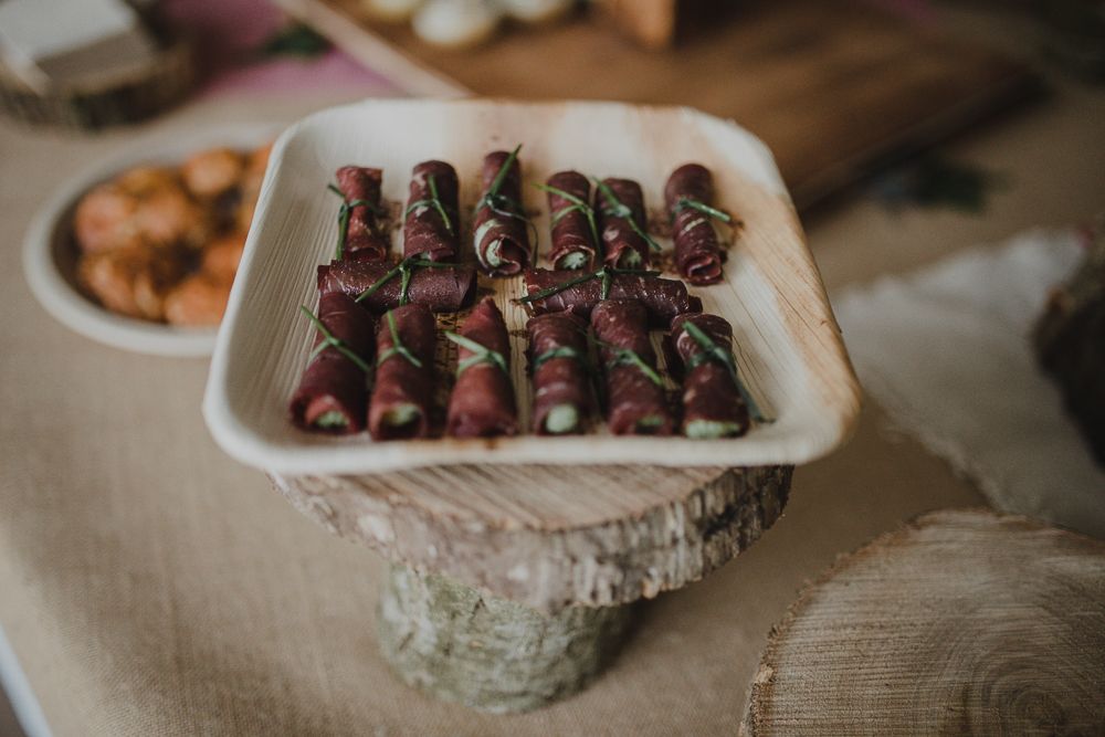 Plate of rolled meat appetizers arranged on a decorative serving dish.