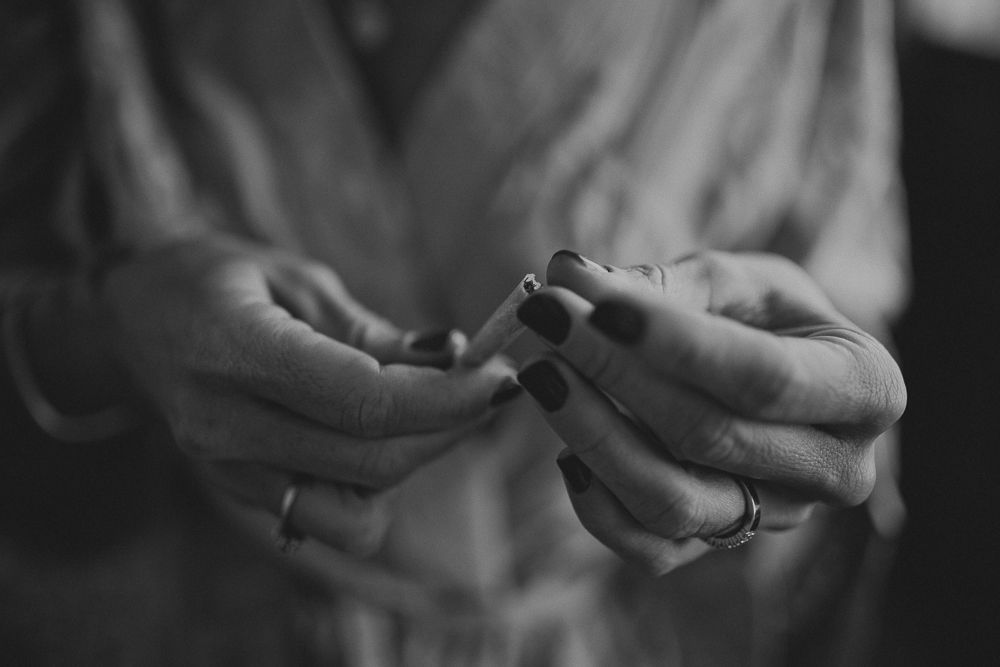 Close-up black and white shot of hands holding small object with ring visible.
