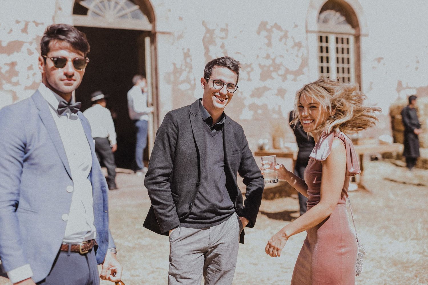 Guests mingling and chatting during an outdoor celebration at a rustic venue.
