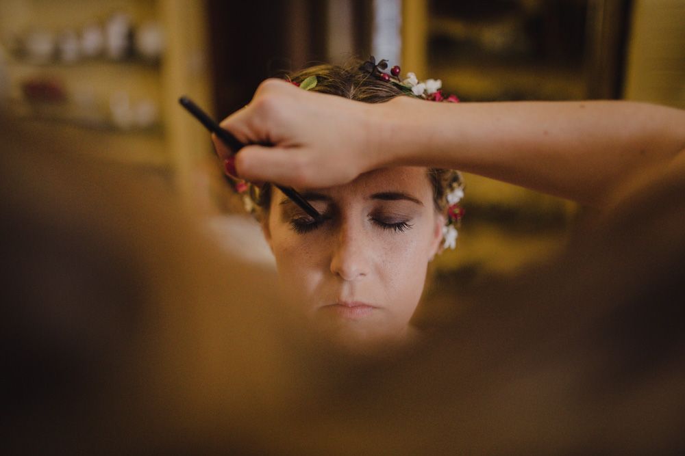Makeup artist applying cosmetics during wedding preparation.