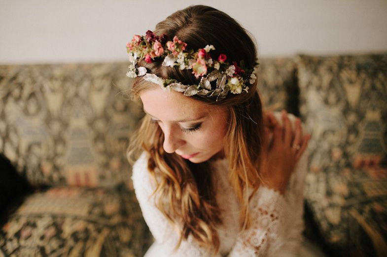Delicate floral crown with pink roses adorns long flowing hair.