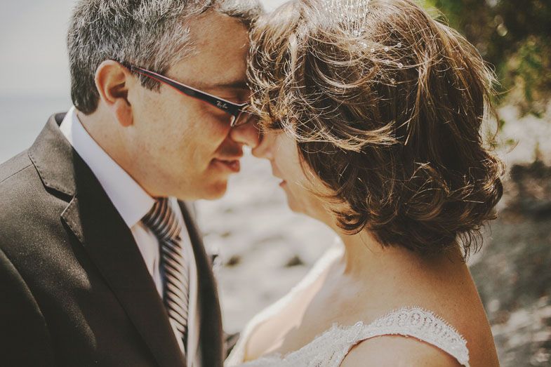 An intimate close-up moment between a couple against a natural backdrop.