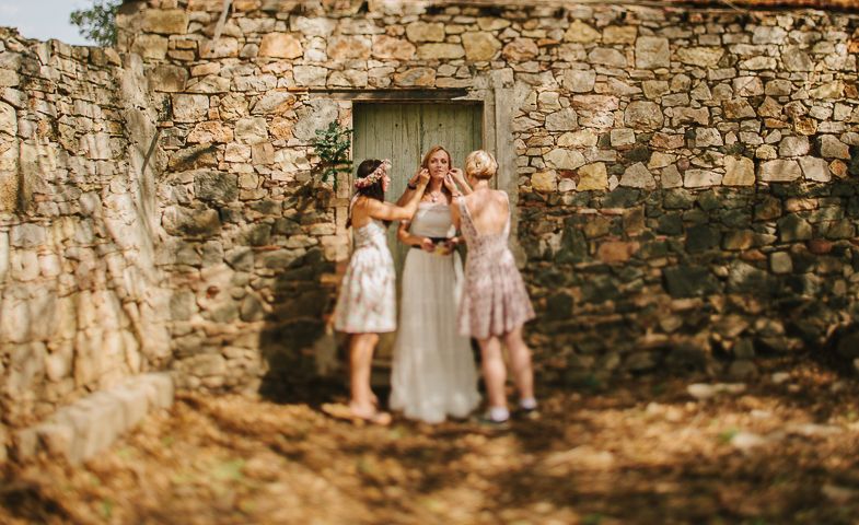 Wedding celebration moment captured against historic stone wall architecture.
