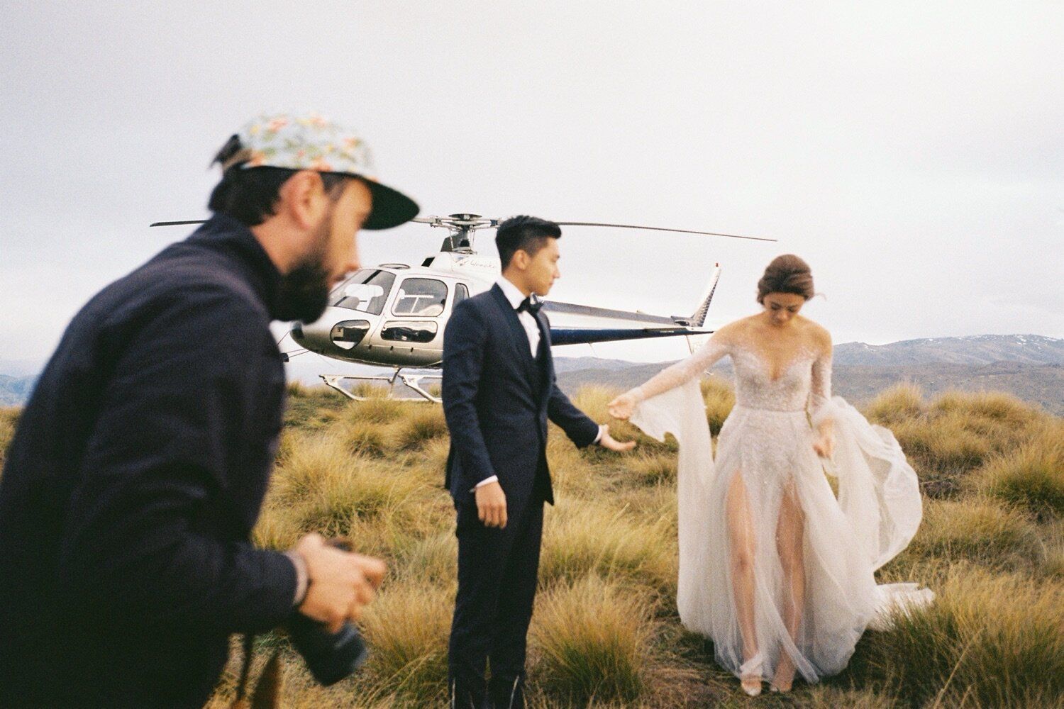 Wedding photo shoot behind the scenes with helicopter in mountain setting.
