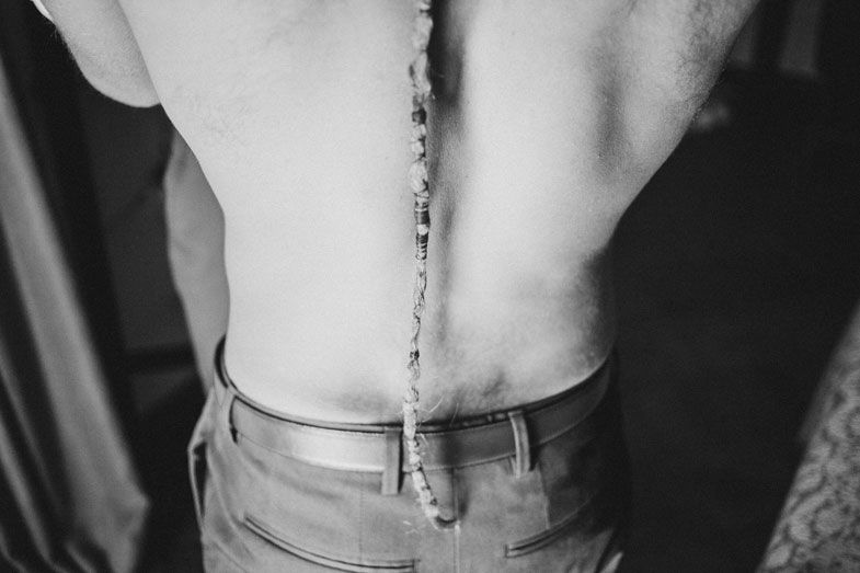 Artistic black and white detail shot of a formal dress shirt and suspenders.