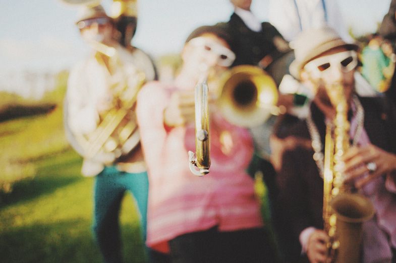 Blurry motion shot of musicians playing brass instruments outdoors.
