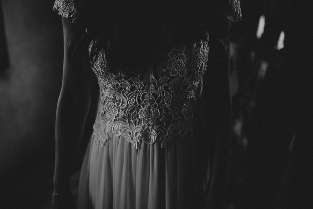 Close-up detail shot of intricate lace bodice on a wedding dress in black and white.