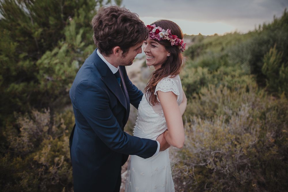 A romantic wedding portrait with the couple embracing against a dusky natural backdrop.