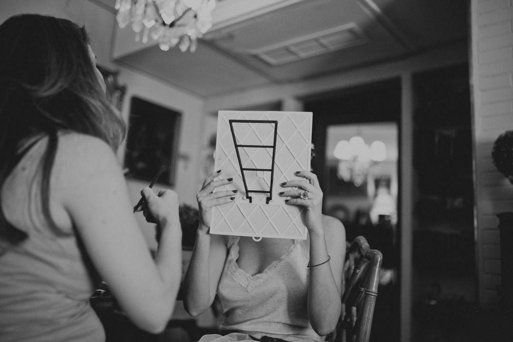 Black and white image of wedding preparation with someone holding a drawing.