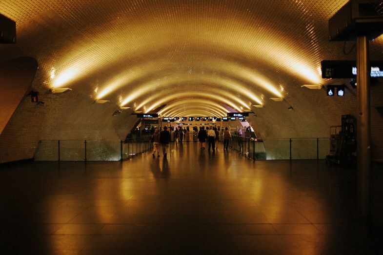 Long underground tunnel with arched ceiling and warm ambient lighting creating dramatic perspective.