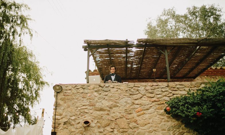 Stone wall balcony overlooking an outdoor wedding venue.