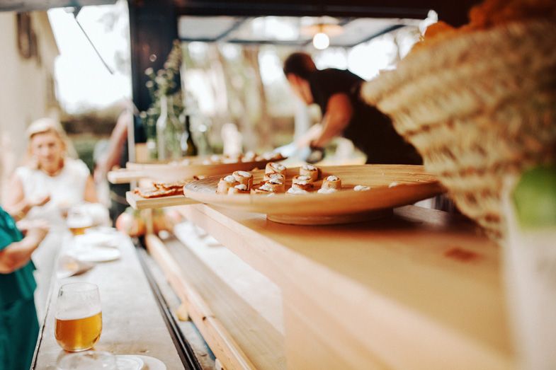 Wedding catering station with appetizers being served on wooden boards.