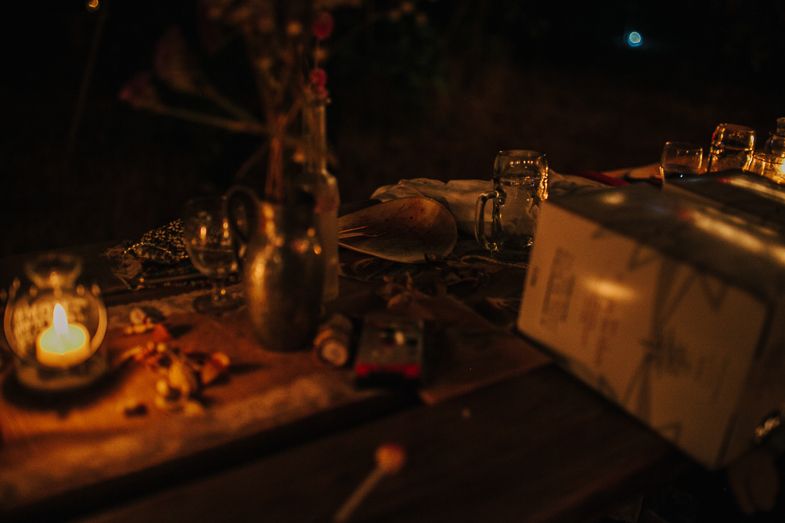 Rustic table setting with glowing lantern and decorative items creating warm ambient lighting at night.