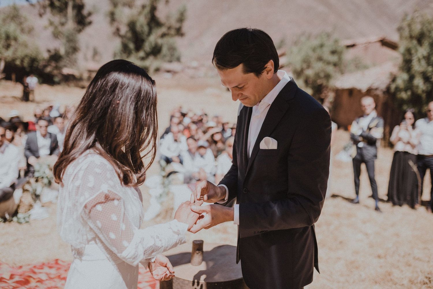A couple exchanging rings during their outdoor desert wedding ceremony.