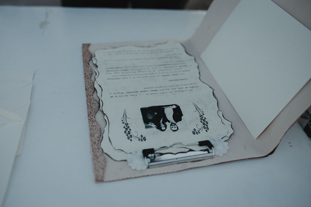 Wedding invitation or document with decorative border lying on white surface.