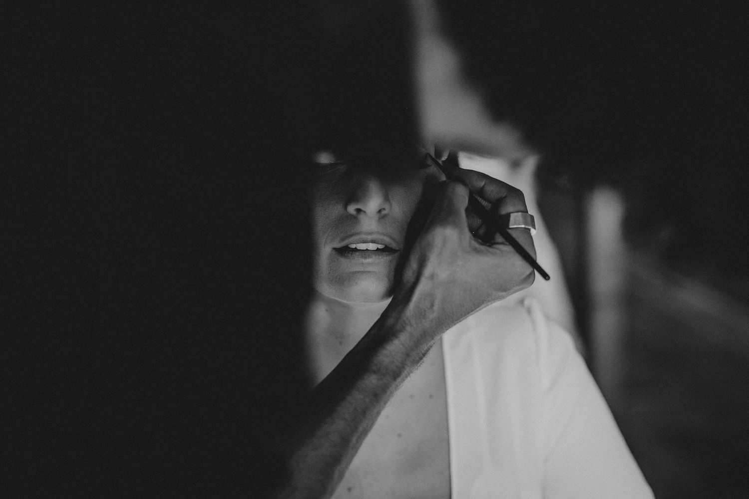 A black and white intimate moment captured during wedding preparations.