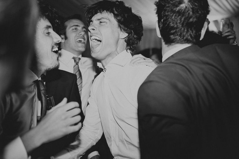 Black and white photo capturing energetic dancing and celebration at a party.
