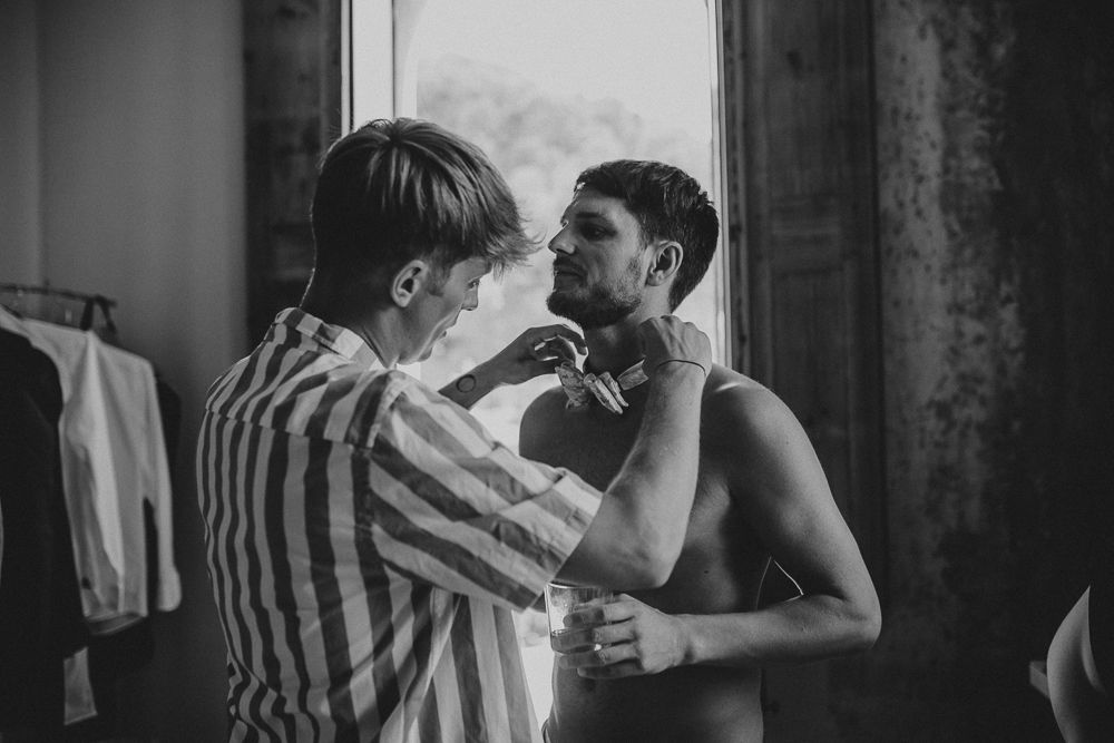 Black and white image of two people sharing an intimate moment by a window.