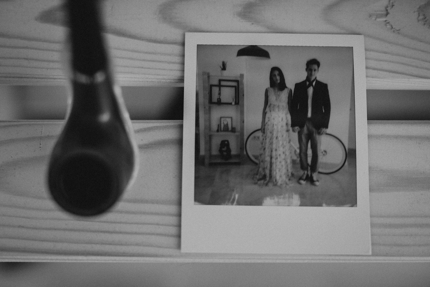 Black and white polaroid photo displayed on wooden surface with microphone silhouette.