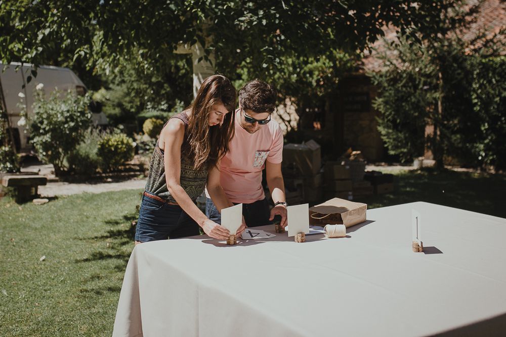 Couple playing games at outdoor table with white tablecloth in backyard setting.