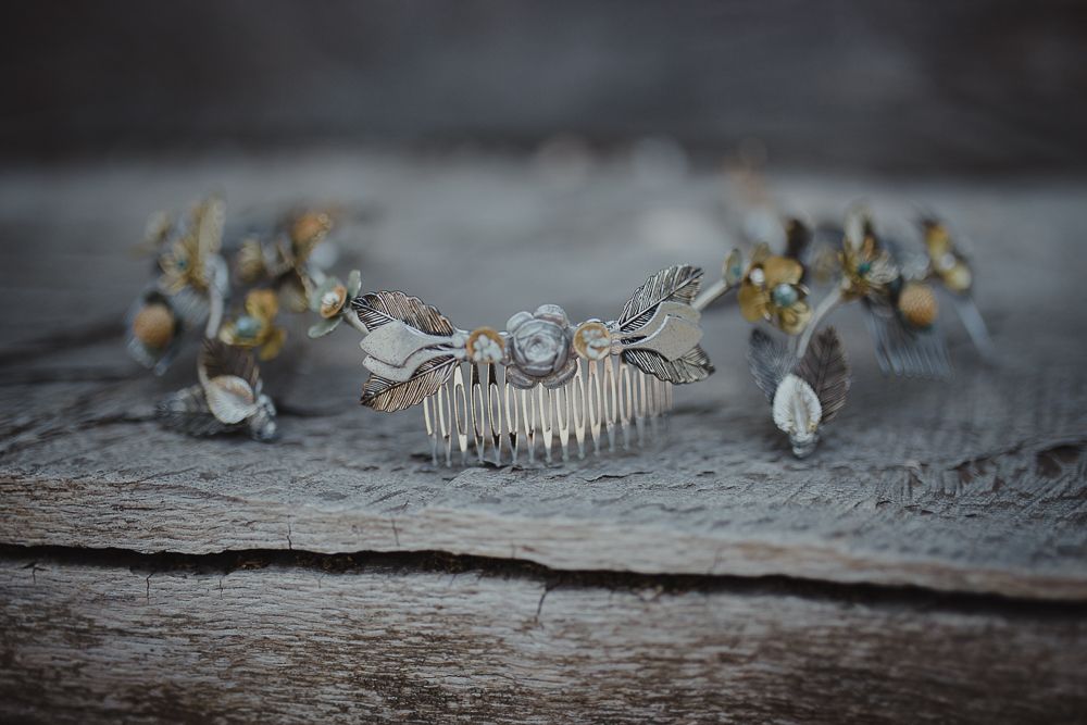 Elegant bridal hair accessories with crystals and floral details on weathered wood surface.