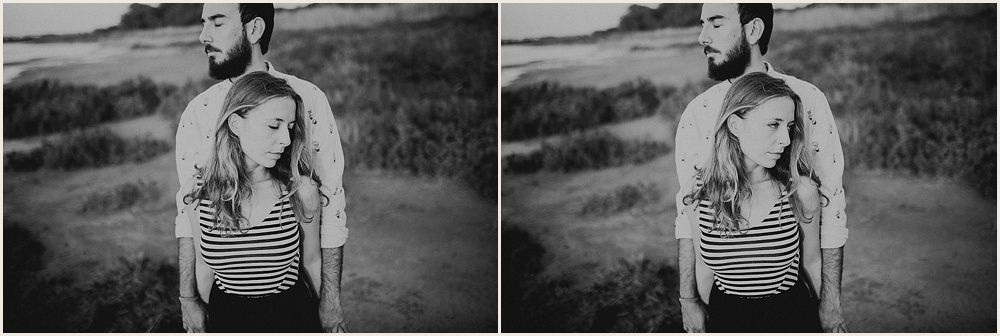 Black and white portrait session in a grassy field at sunset.