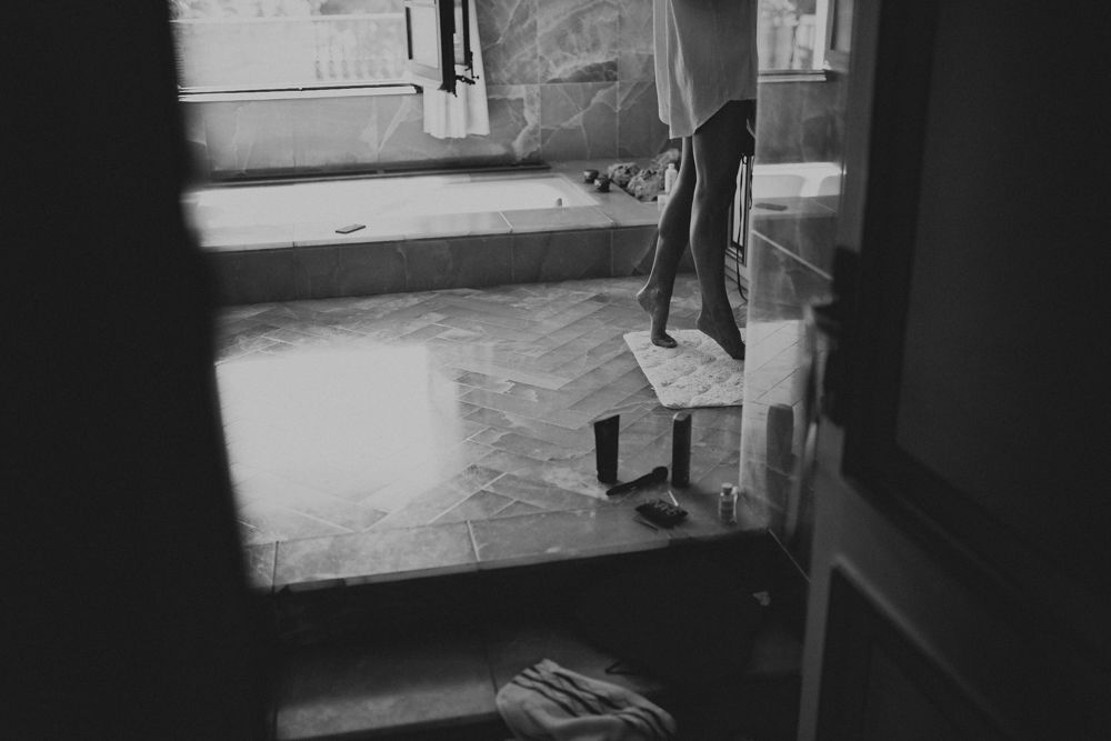 A shadowy figure viewed through a doorway in black and white.