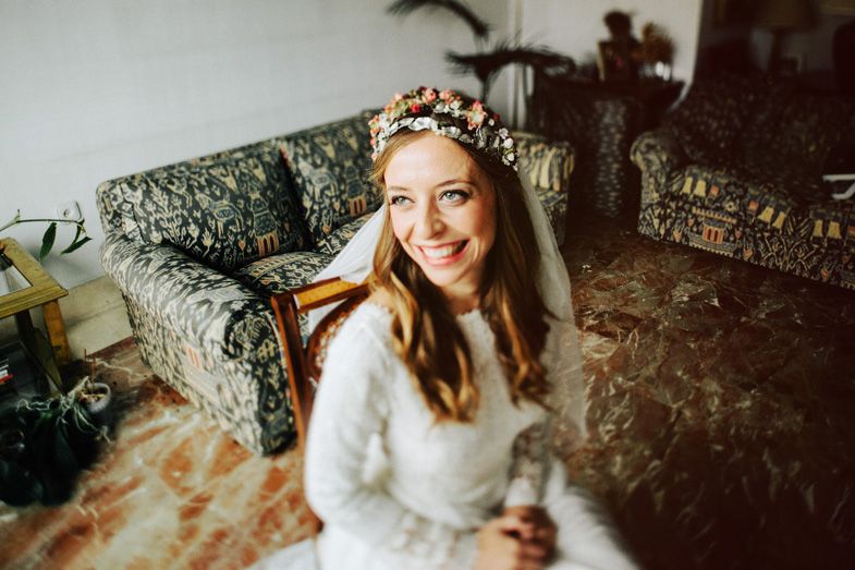 A wedding day moment captured on a vintage floral sofa with indoor greenery.