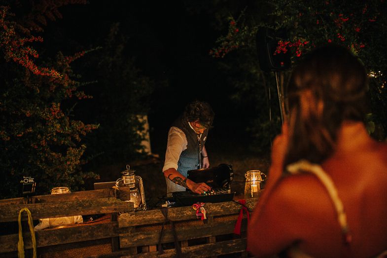 Outdoor evening setup with lanterns and decorative tables illuminated by warm lighting.