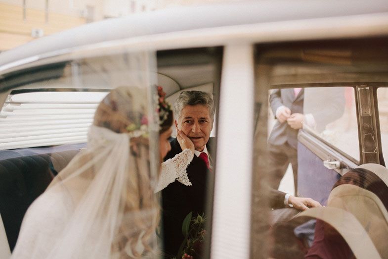 A wedding moment captured through a vintage car window.
