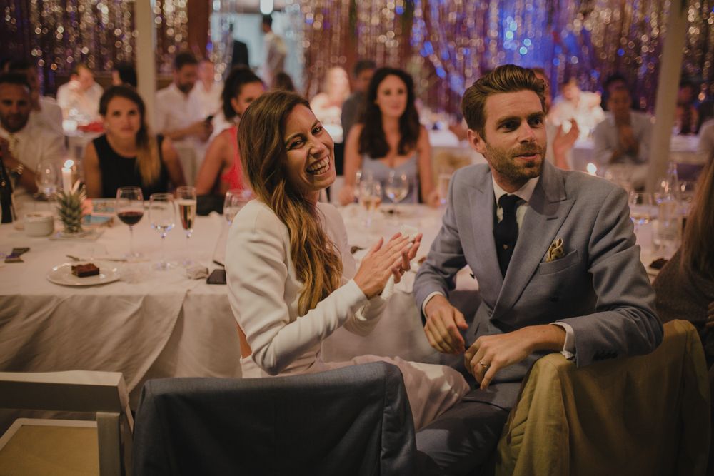 Wedding guests enjoying dinner at an elegantly decorated indoor reception.