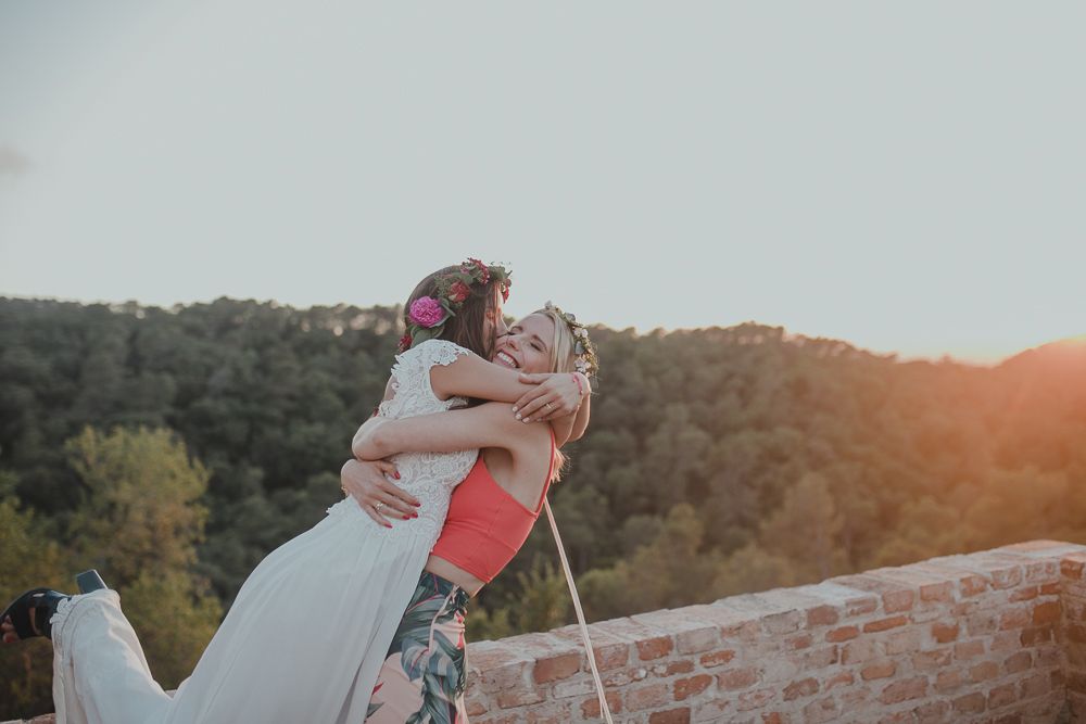 A sunset wedding moment captured on a brick terrace with mountains in the background as two people embrace.