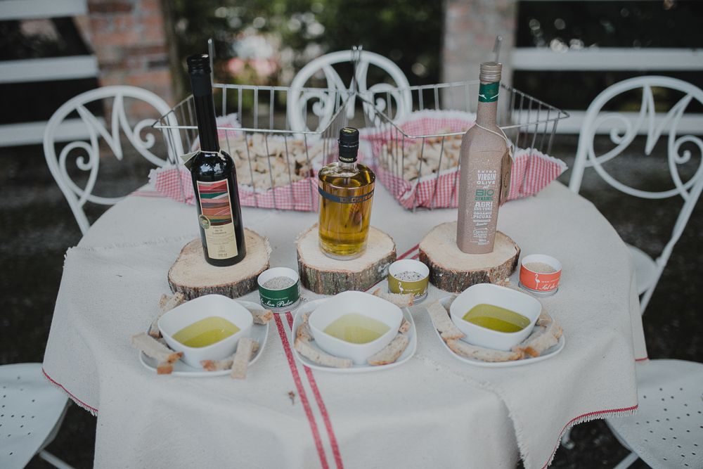 Elegant white table setting with wine bottles and teacups at an outdoor event.