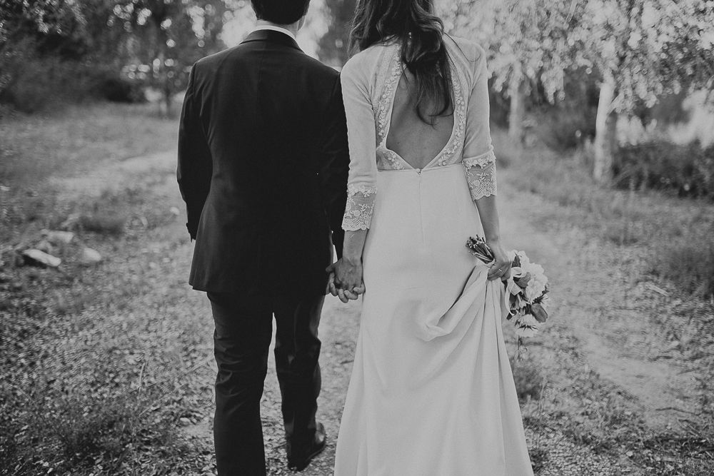 A wedding couple poses among tall pine trees for an intimate forest portrait.