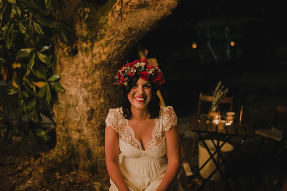 Evening wedding celebration under tree with festive lighting and floral decor.