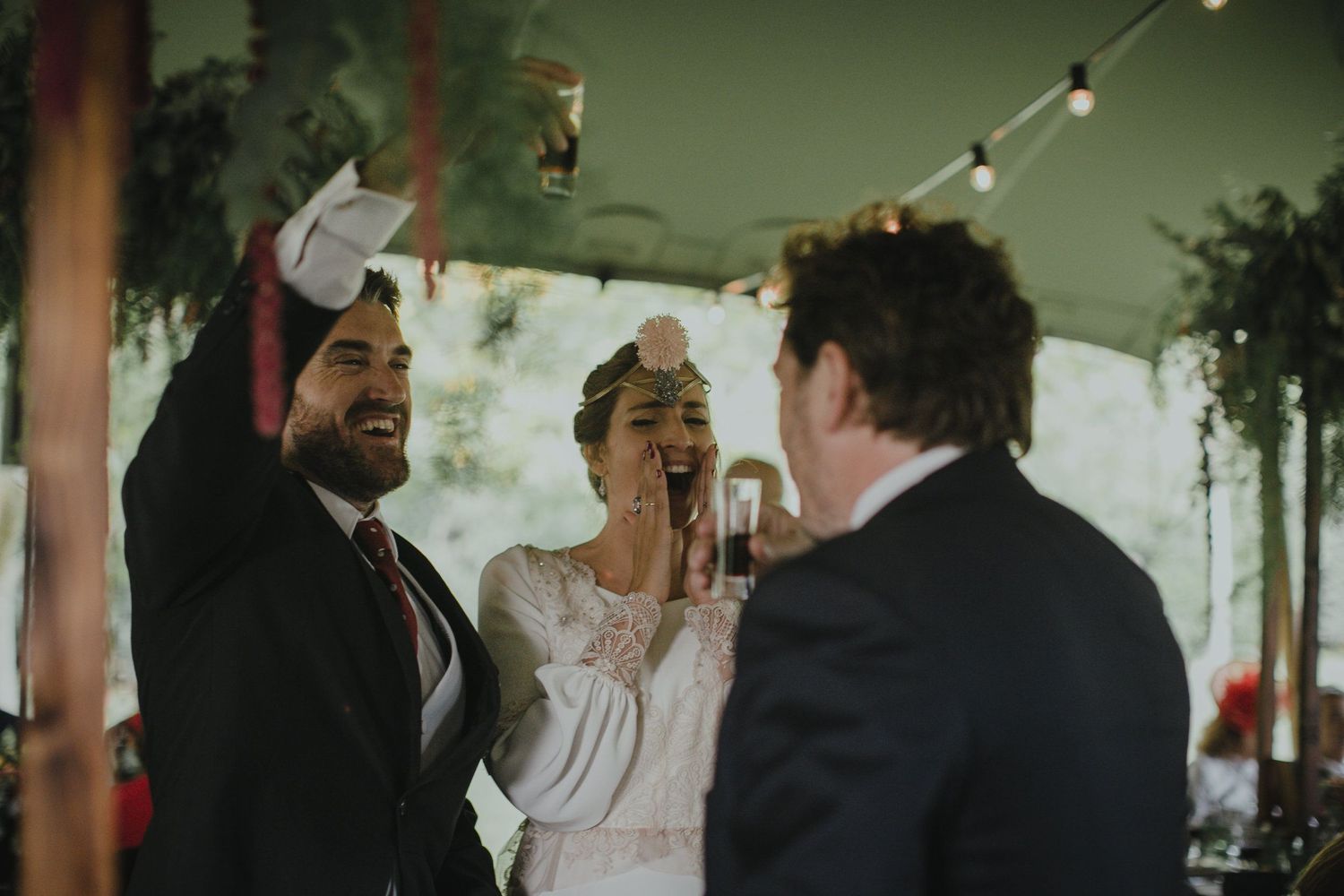 A joyous celebration moment captured during a wedding ceremony under a tent.