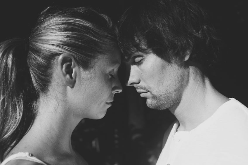 An intimate black and white portrait of a couple in profile.