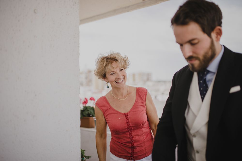 Candid moment during wedding preparations in bright indoor setting.