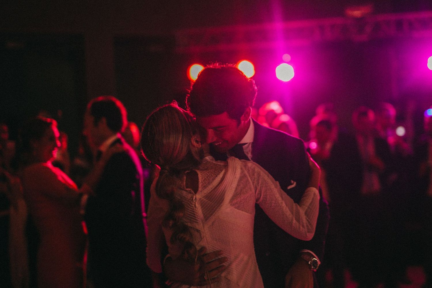 Wedding reception dance party with colorful lighting and festive atmosphere.