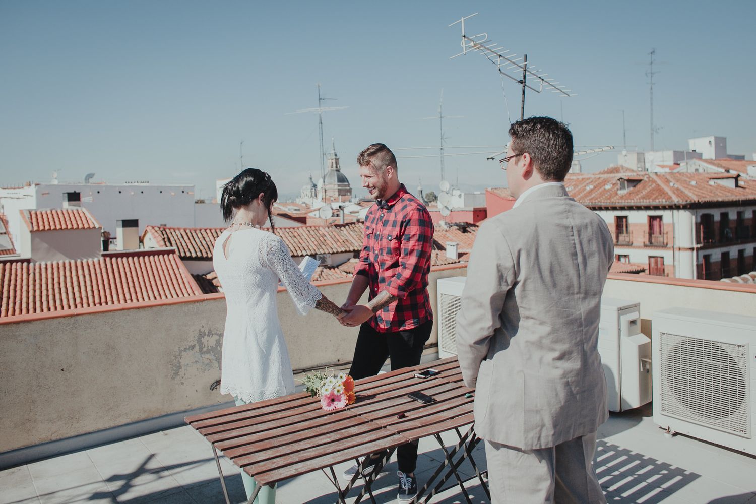 Small gathering of people on urban rooftop with city views.