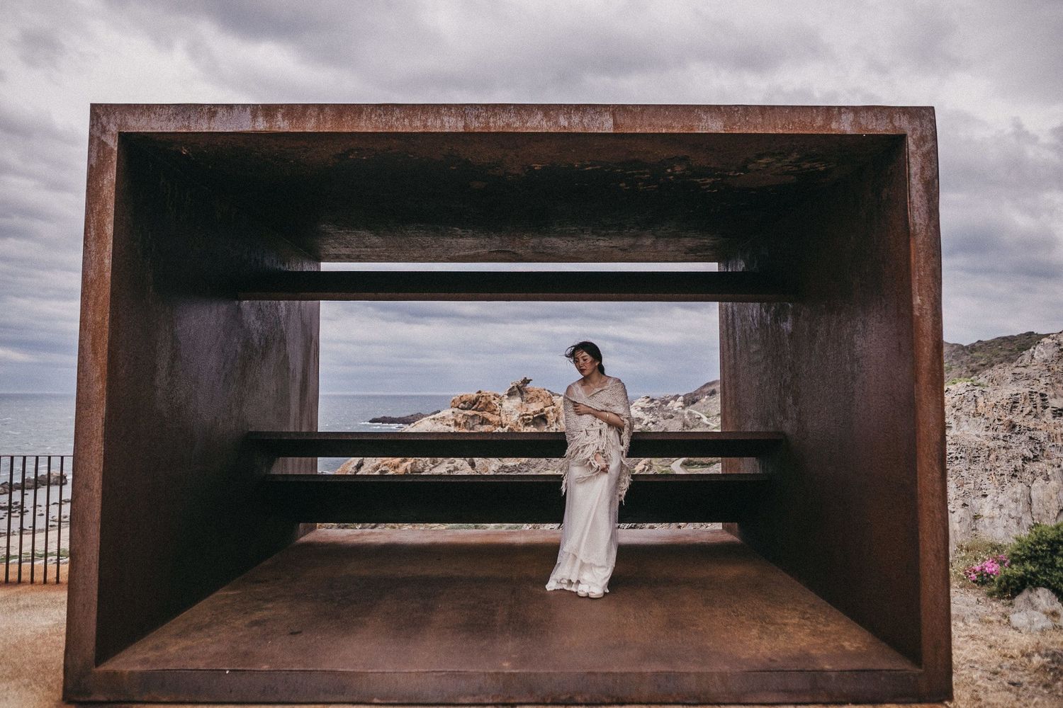 A modern metal viewing platform frames a scenic desert mountain vista.